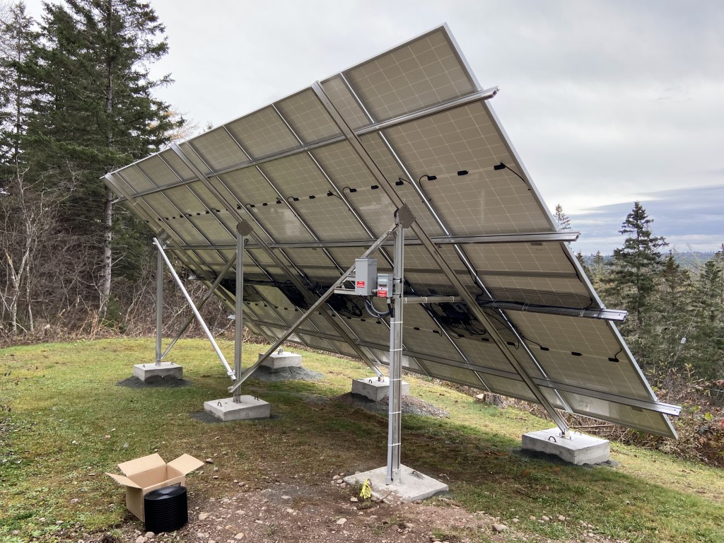 Rear view of a ground-mounted solar array showing racking and wiring